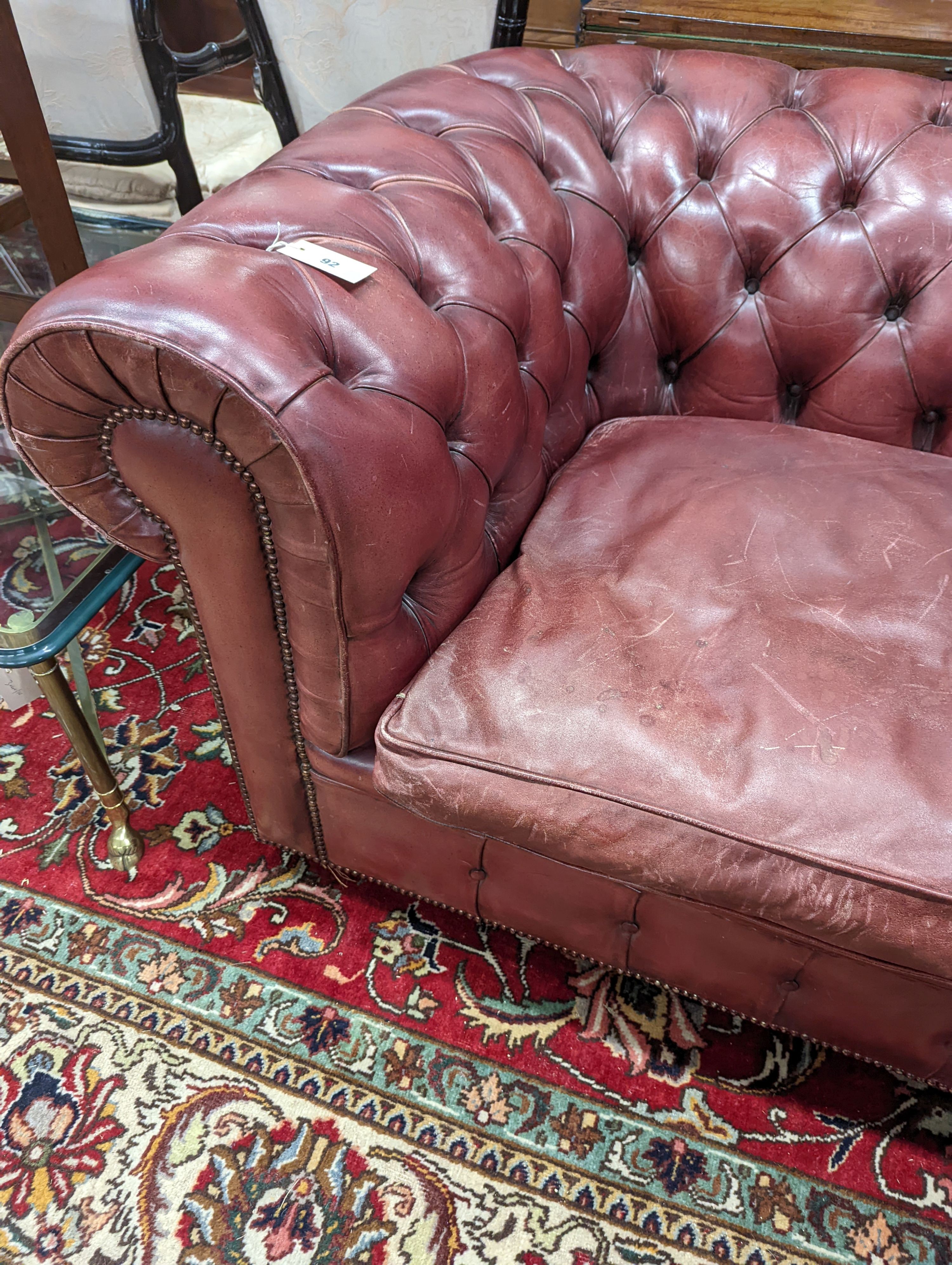 A Victorian style buttoned burgundy leather Chesterfield settee, length 172cm, depth 90cm, height 73cm